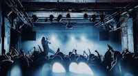 a crowd of people at a concert in a dark room